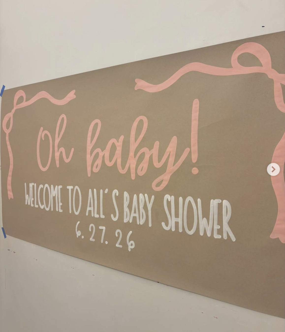 Dusty pink baby shower banner reading Oh Baby, Welcome to All's Baby Shower